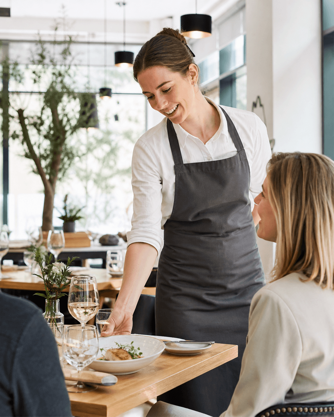 Restaurant server delivering attentive service to a guest